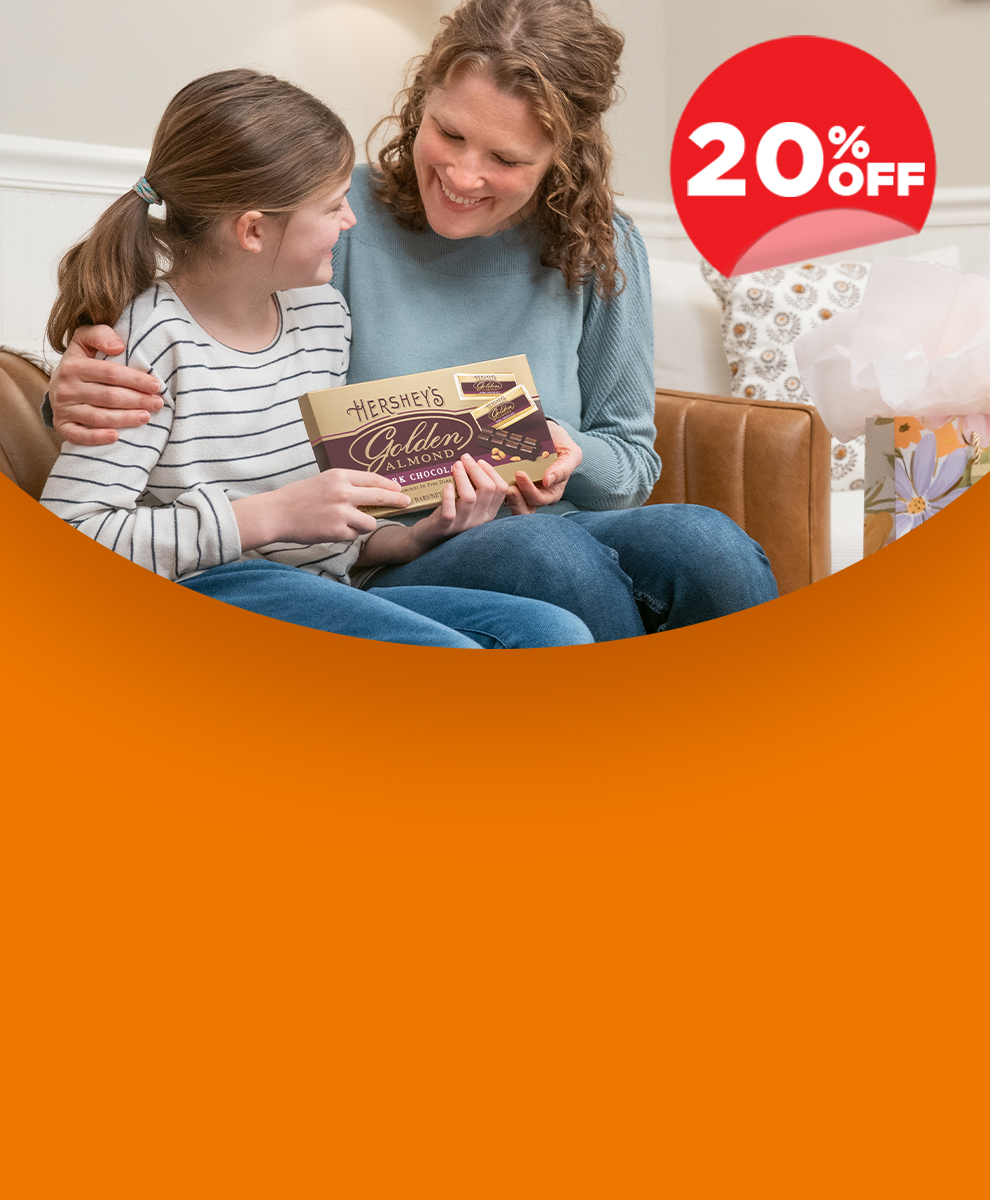 Daughter gifting her mother a HERSHEY'S Caramels pouch and a HERSHEY'S GOLDEN ALMOND 5-pack of dark chocolate candy bars with almonds for Mother's Day