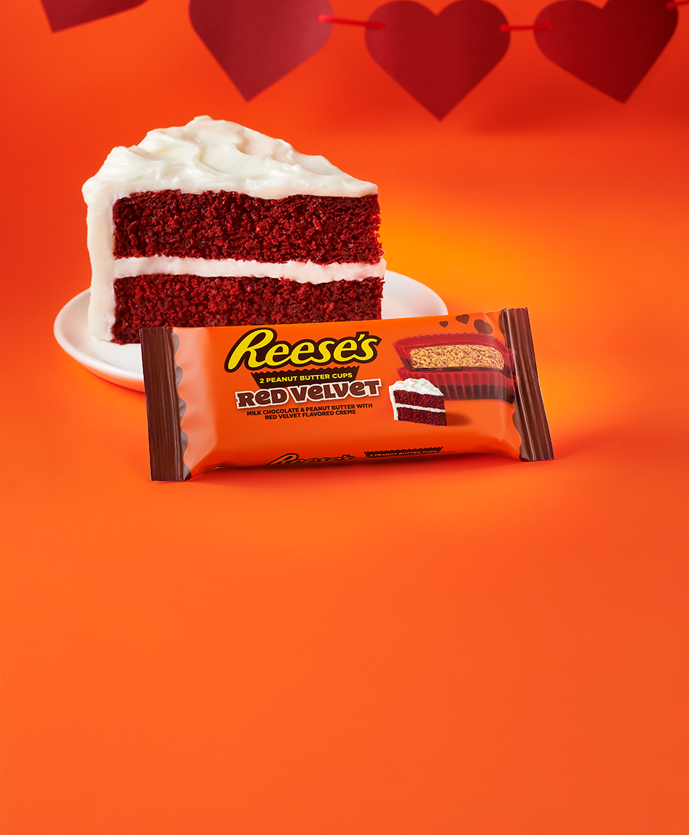 Promotional graphic featuring REESE'S Red Velvet Peanut Butter Cups next to a slice of red velvet cake