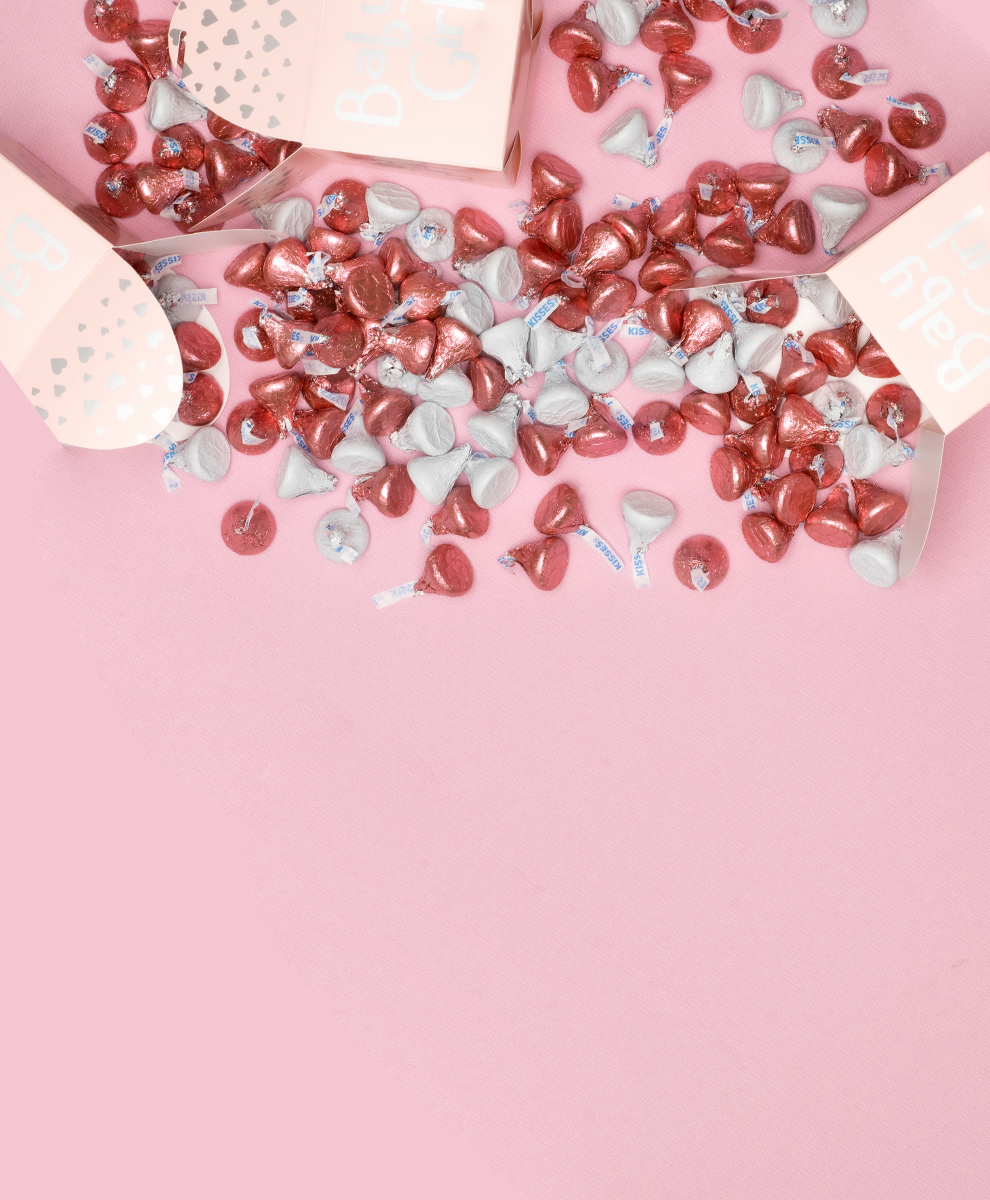 Baby shower favors filled with HERSHEY'S KISSES wrapped in pink and white foil