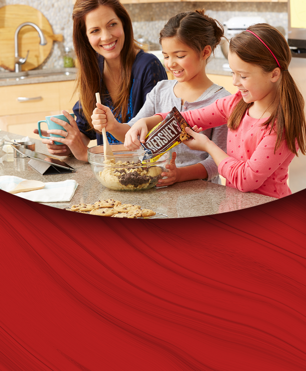 Promotional graphic showing a mother and daughter baking cookies in a kitchen using HERSHEY'S baking chips