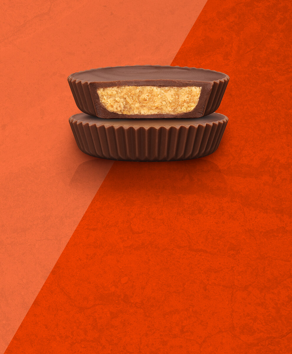 Organic REESE'S Cups stacked on top of one another on orange background