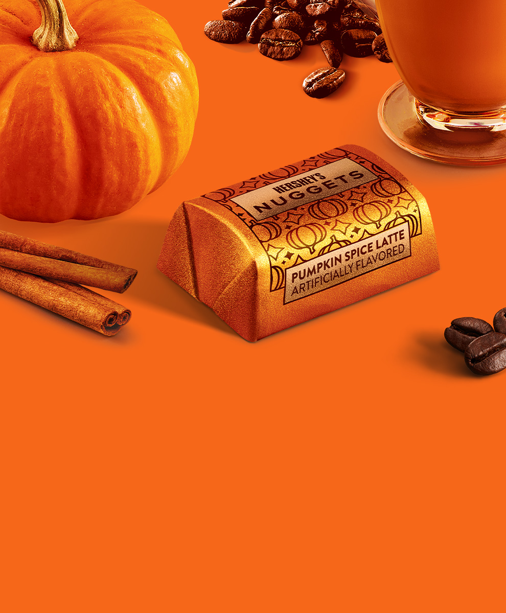 Promotional graphic featuring HERSHEY'S Pumpkin Spice Flavored Nuggets Candy in a fall-themed setting