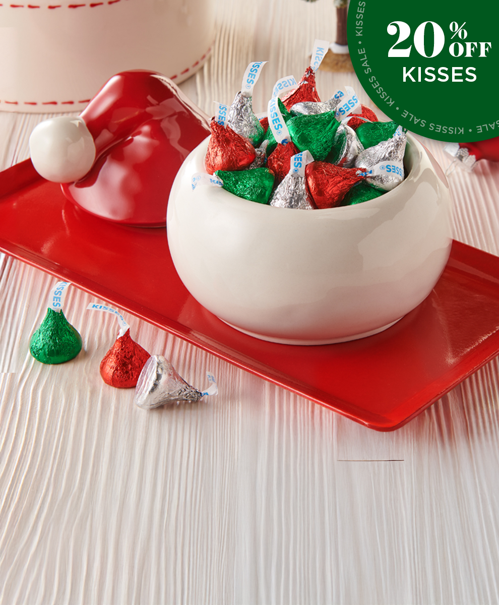 HERSHEY'S Kisses in Red and Green and Silver Foils in Christmas-themed dishware on a tabletop