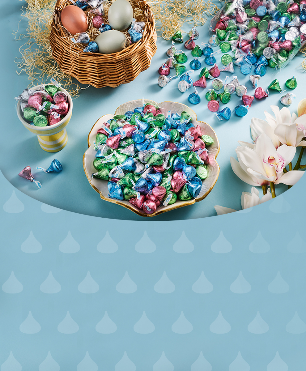 Promotional graphic featuring HERSHEY'S Milk Chocolate Kisses in Pastel colors falling from easter basket