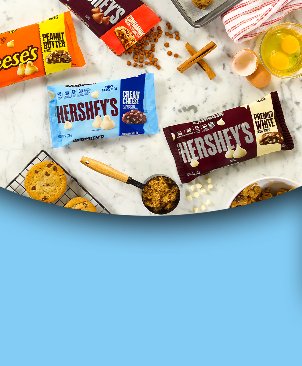 Promotional graphic showing a baking-themed scene with bags of HERSHEY'S and REESE'S baking chips opened and unopened