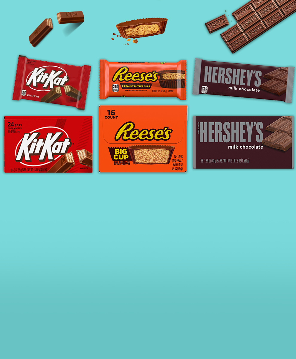 HERSHEY'S and REESE'S and TWIZZLERS and Kit Kat® and PAYDAY boxes of candy bars on a white brick background
