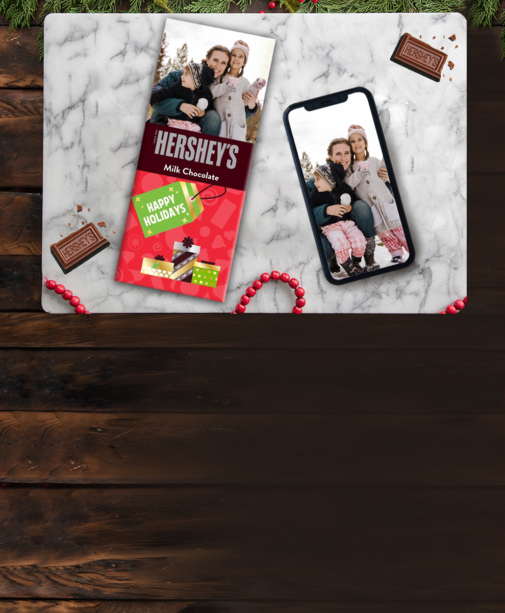 Christmas-themed Personalized HERSHEY'S Chocolate Bar next to smartphone
