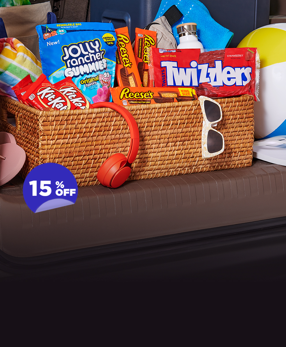 Assorted candies displayed in a wicker basket amongst summer-themed accessories