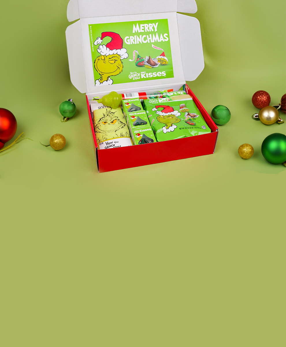 Exclusive Grinch Gift Box open on green tabletop with Christmas ornaments