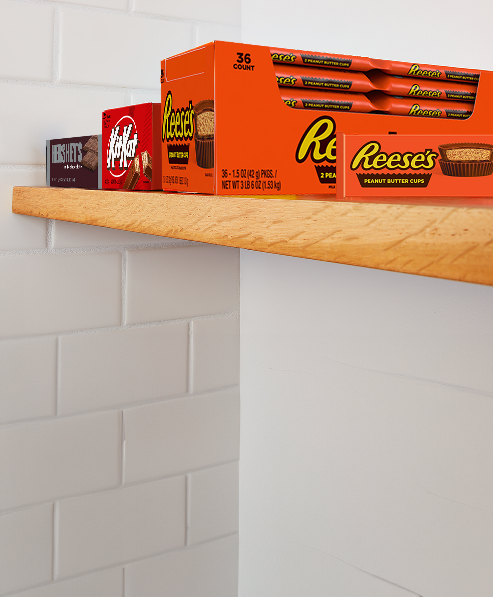 HERSHEY'S and REESE'S and Kit Kat® boxes of candy bars on a pantry shelf