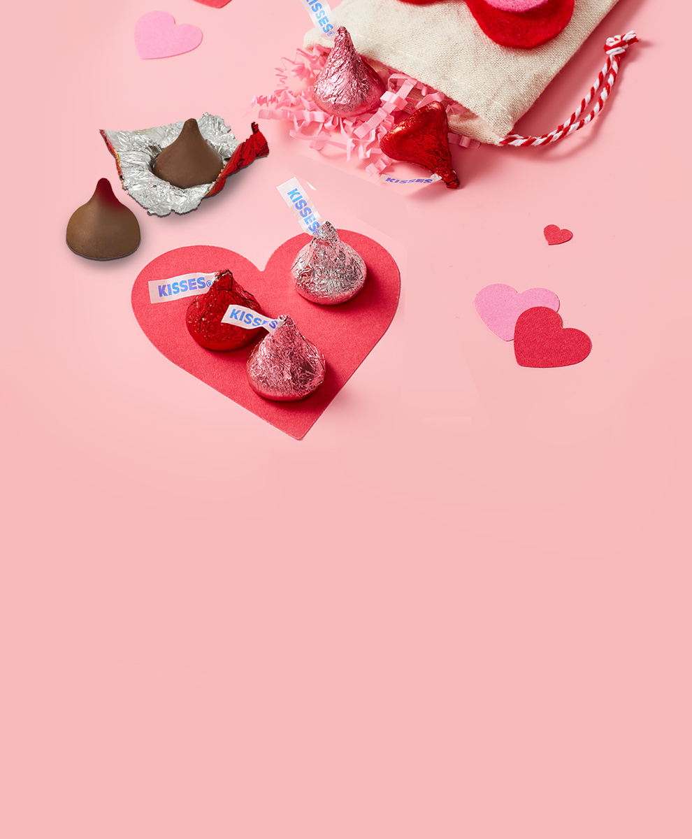 Valentine foil KISSES Chocolates on pink background with hearts & gift bag