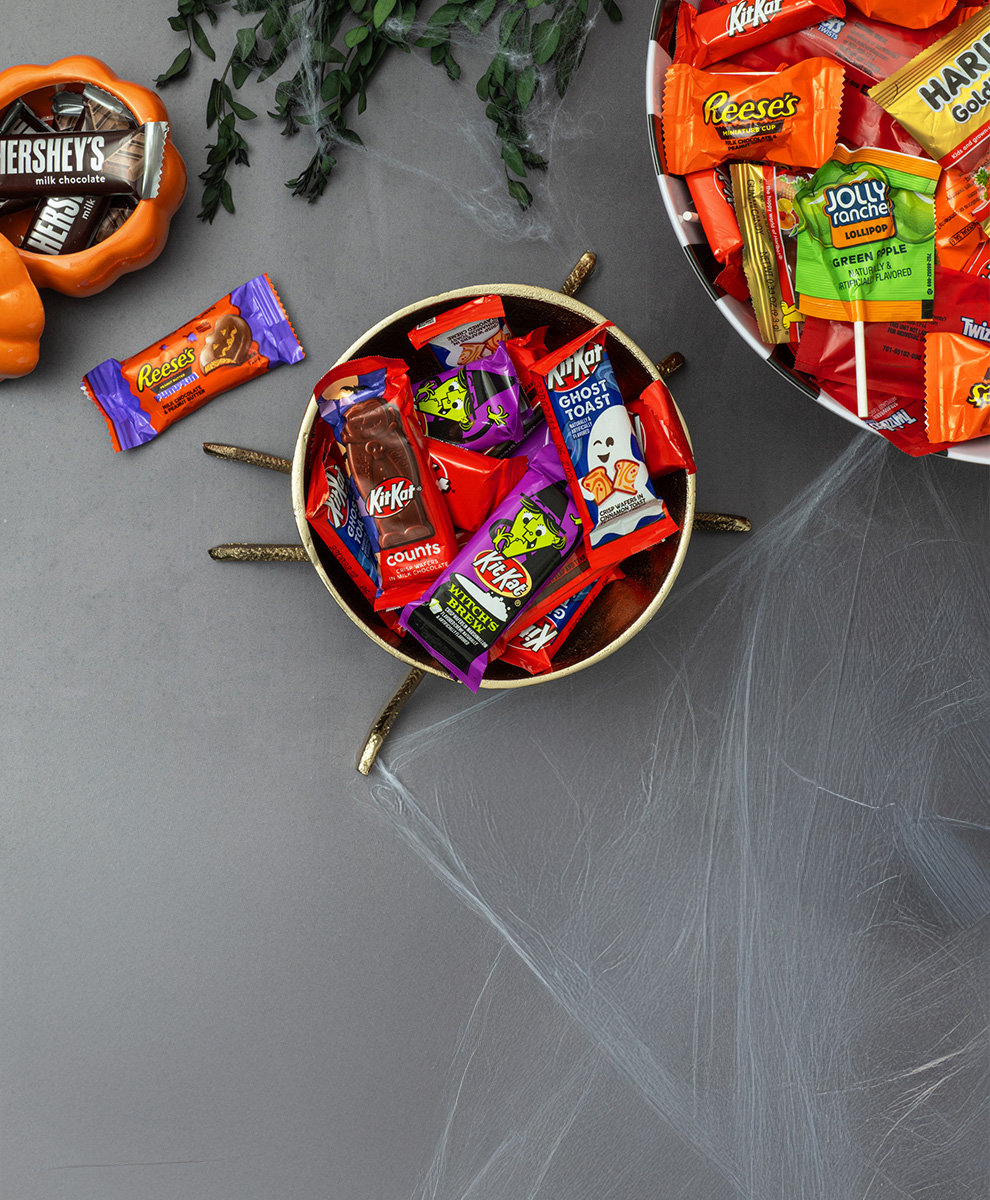 Assorted miniature sized Halloween candies in trick-or-treat bowls