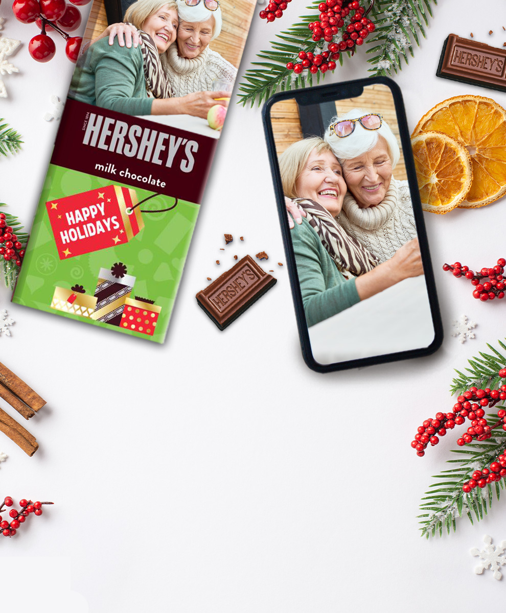 HERSHEY'S Bar with personalized holiday-themed wrapper next to an iPhone