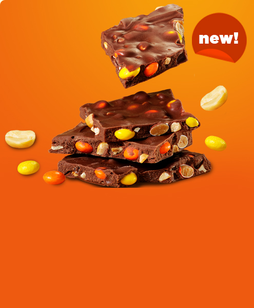 REESE'S Chocolate and peanut butter bark pieces stacked on an orange background