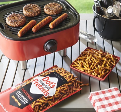 Promotional graphic featuring DOTS homestyle pretzels on a spring picnic blanket