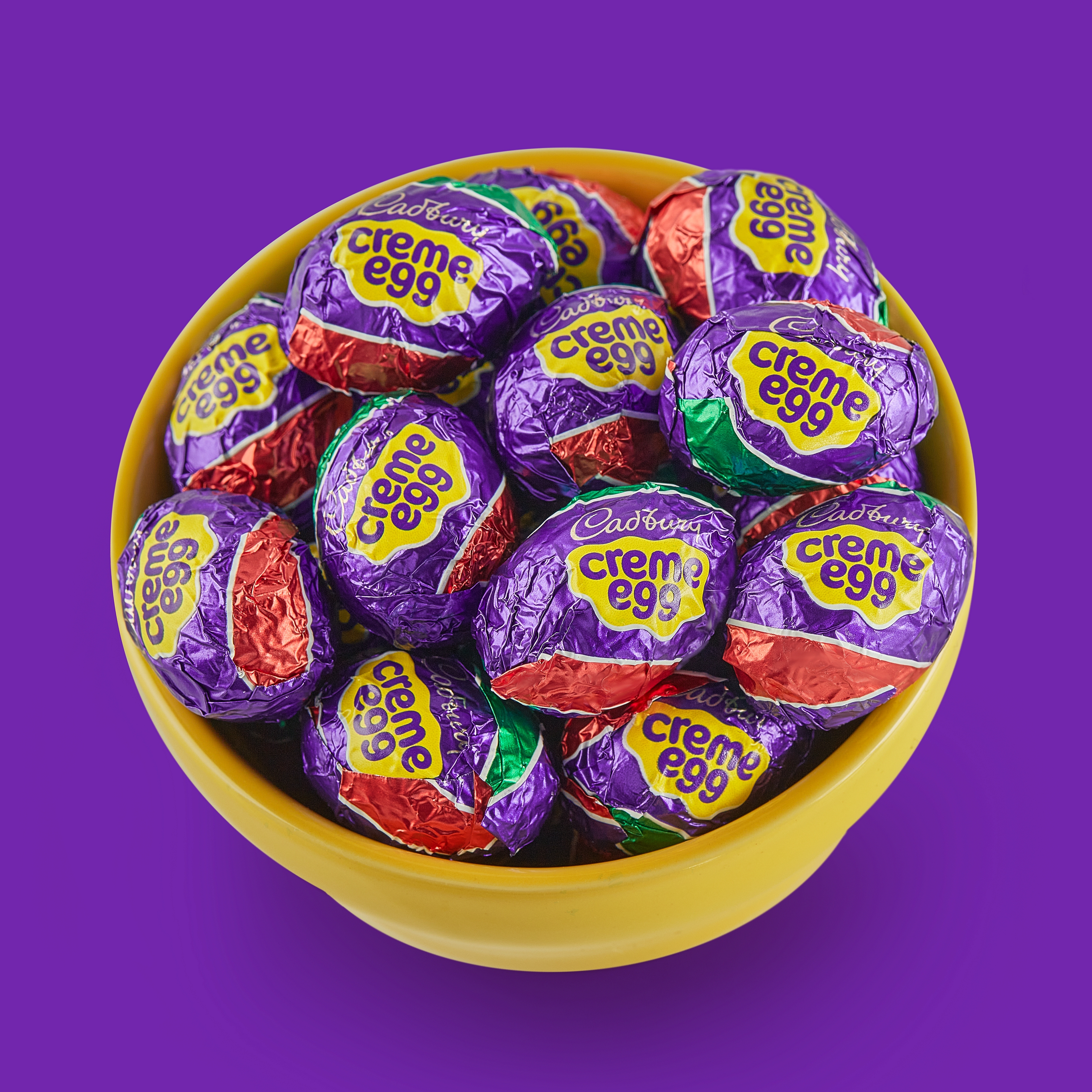 Promotional graphic showing a bowl filled with CADBURY Creme Eggs