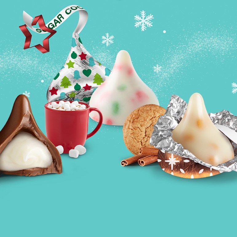 Promotional graphic featuring an assortment of seasonal KISSES on a blue background