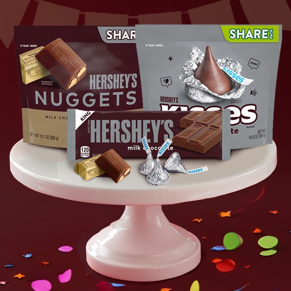 HERSHEY'S products on a cake stand surrounded by confetti