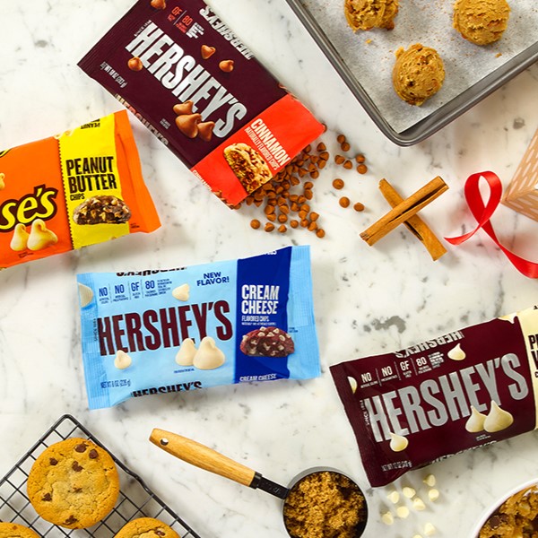 Baking-themed graphic featuring assorted flavor bags of HERSHEY'S and REESE'S baking chips