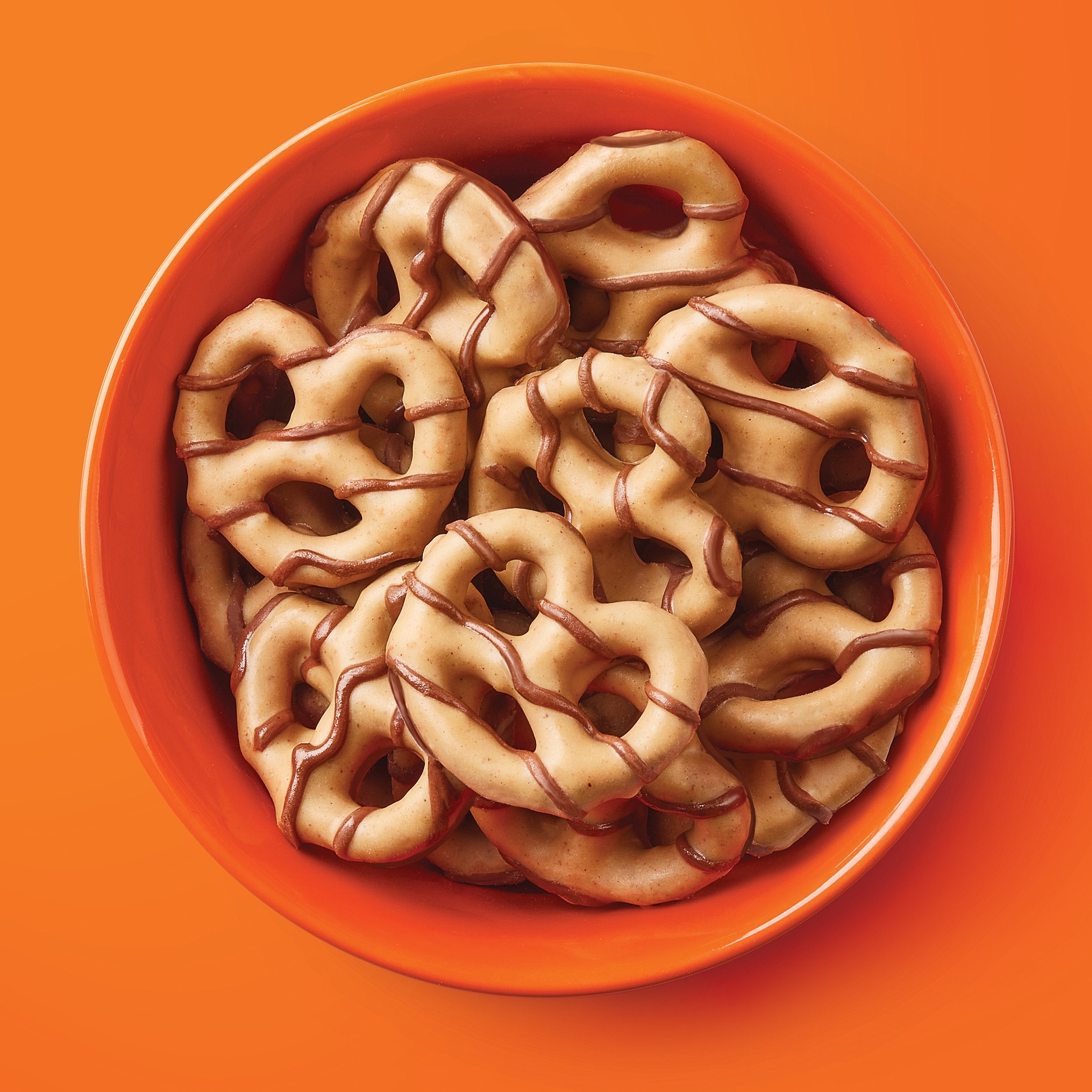 REESE'S Peanut Butter Dipped Pretzels in a bowl on an orange background