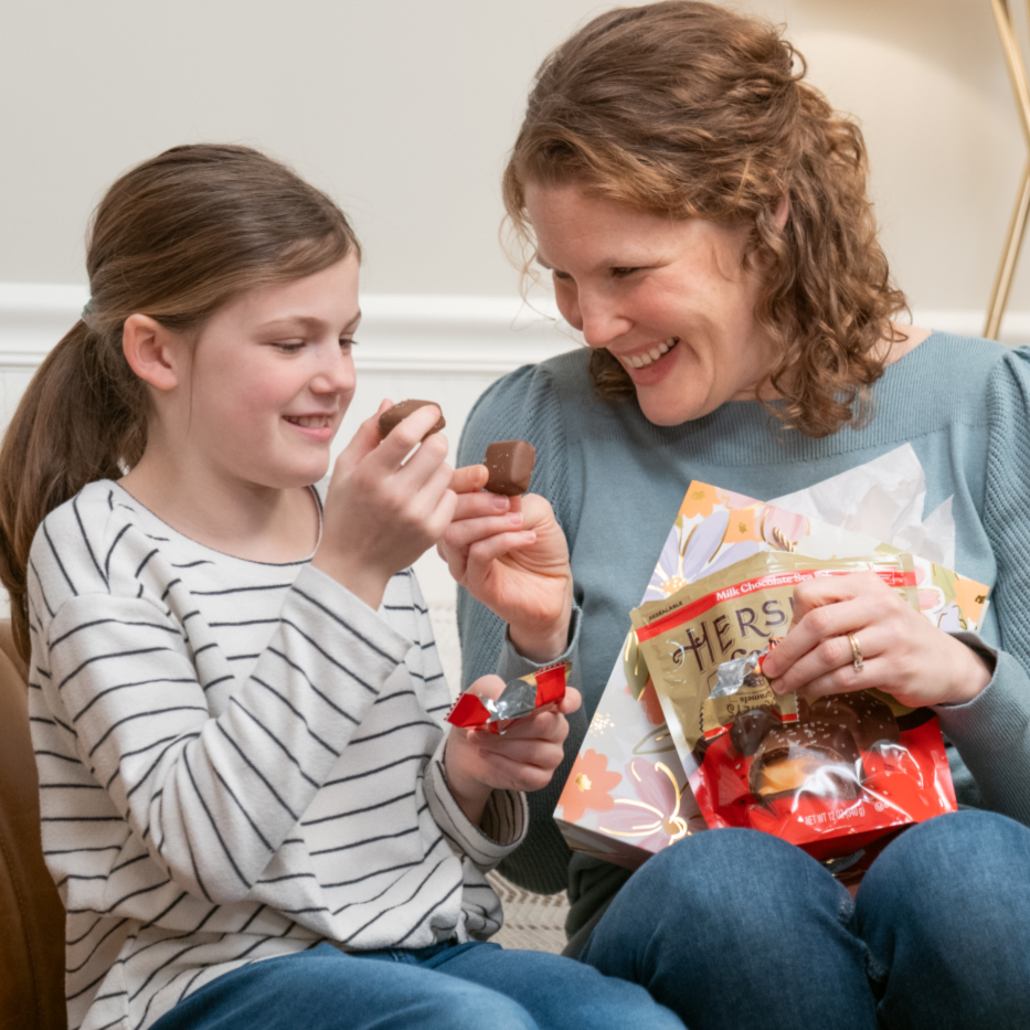 Daughter gifting her mother a HERSHEY'S Caramels pouch for Moher's Day