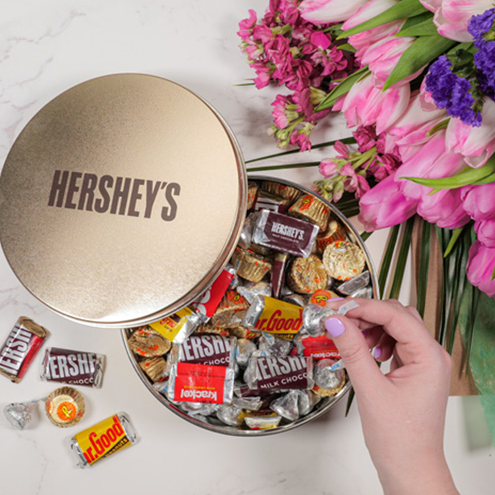 HERSHEY'S and Golden Almond Gift assortment placed next to a bouquet of flowers