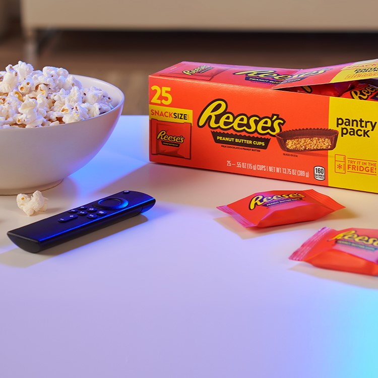 REESE'S Peanut Butter Cups Pantry Pack and SKINNY POP popcorn in a bowl on a living room table