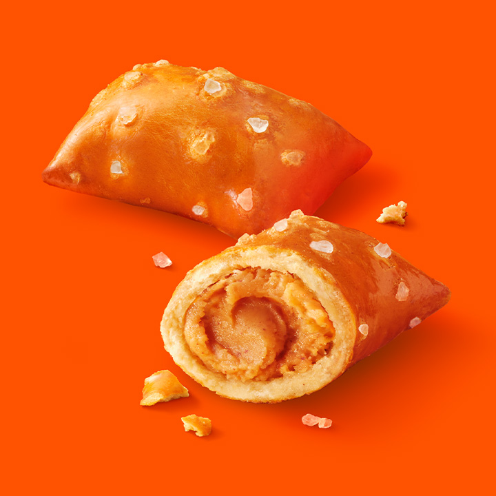REESE'S Peanut Butter Filled Pretzels in a bowl on an orange background