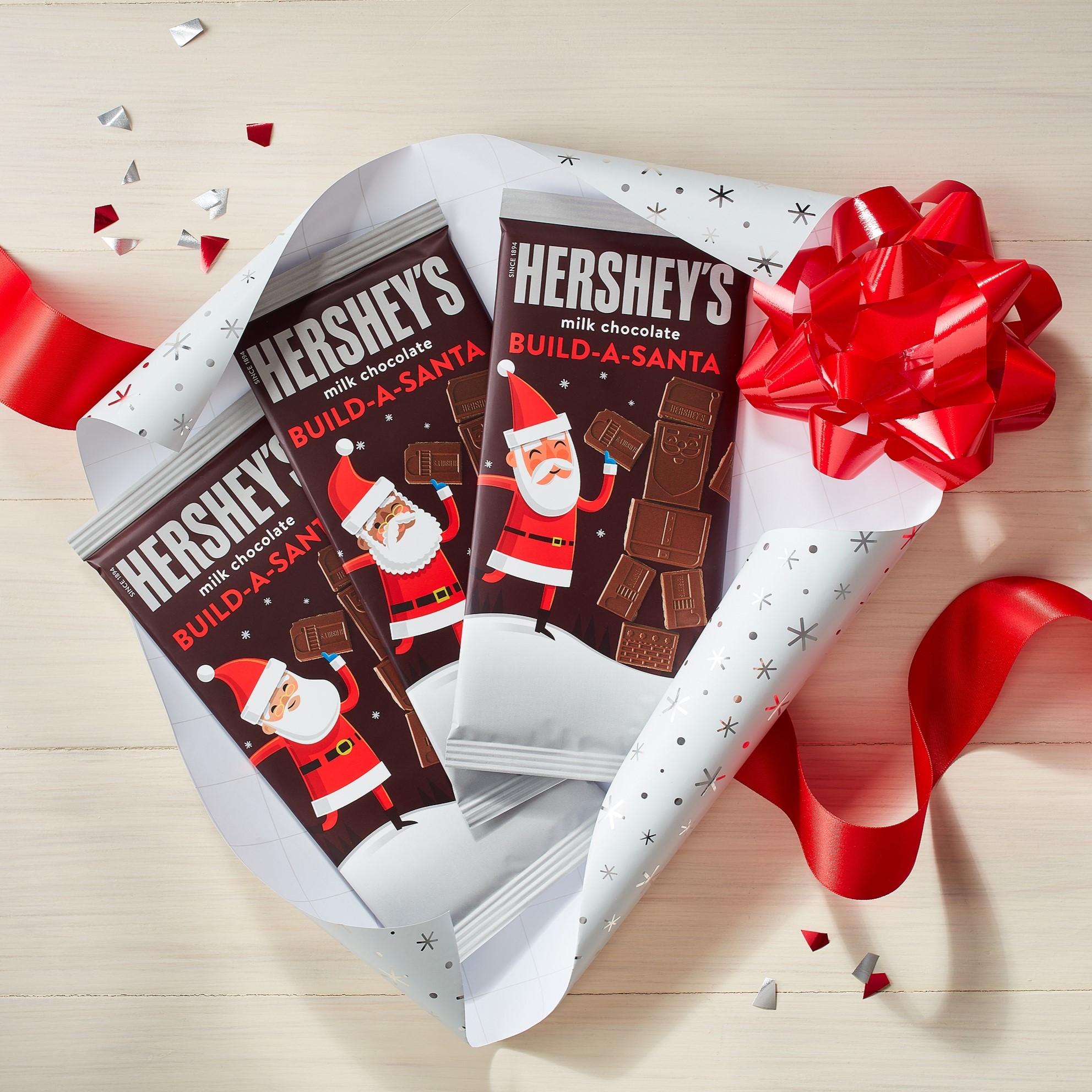 HERSHEY'S Build-A-Santa XL Chocolate Bars partially unwrapped alongside holiday-themed ribbon