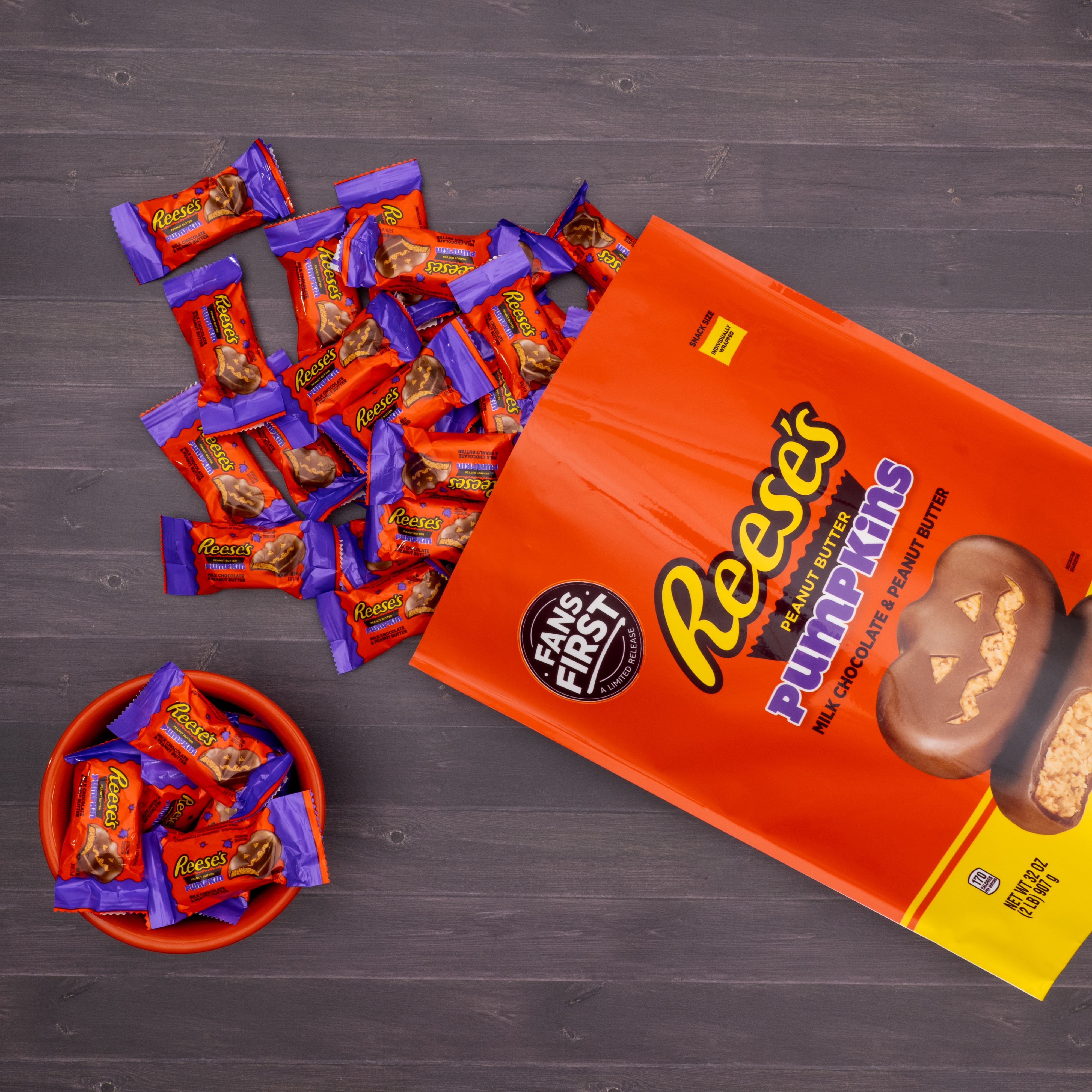 Individually wrapped REESE'S Fans First Peanut Butter Pumpkins spilling out from their bag