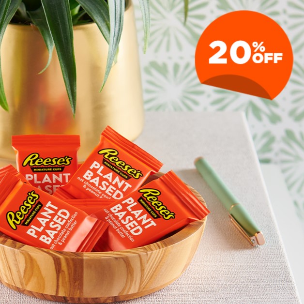 REESE'S Individually Wrapped Plant-Based Peanut Butter Cups in a wooden bowl on a tabletop