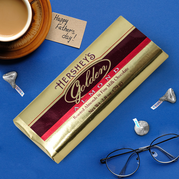 Promotional graphic with a Father's Day gifting theme featuring a HERSHEY'S GOLDEN ALMOND milk chocolate candy bar and milk chocolate HERSHEY'S Kisses