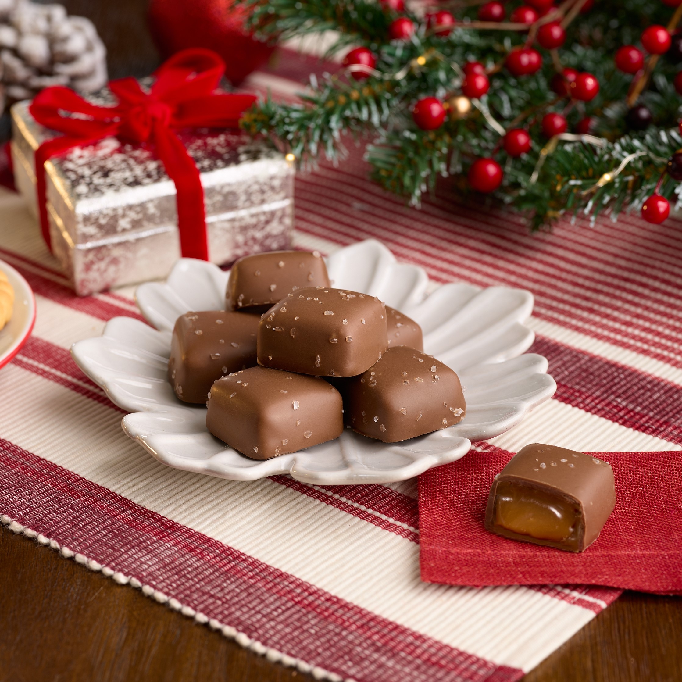 Promotional graphic showing HERSHEY'S Caramels Displayed on a plate surrounded by Christmas-themed decor