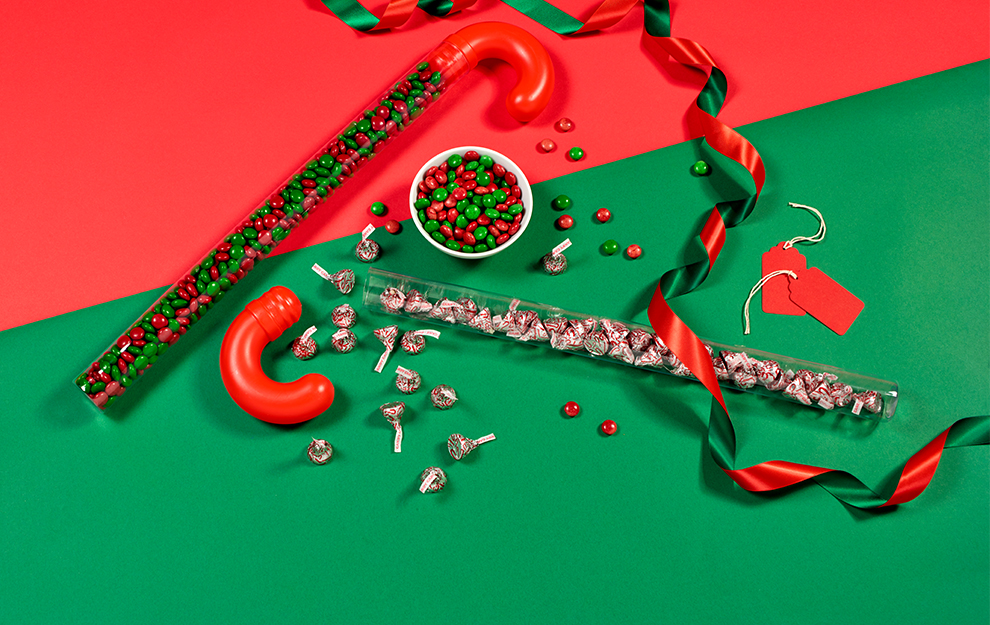 Candy Cane toys filled with Hershey's candy on a red and green background