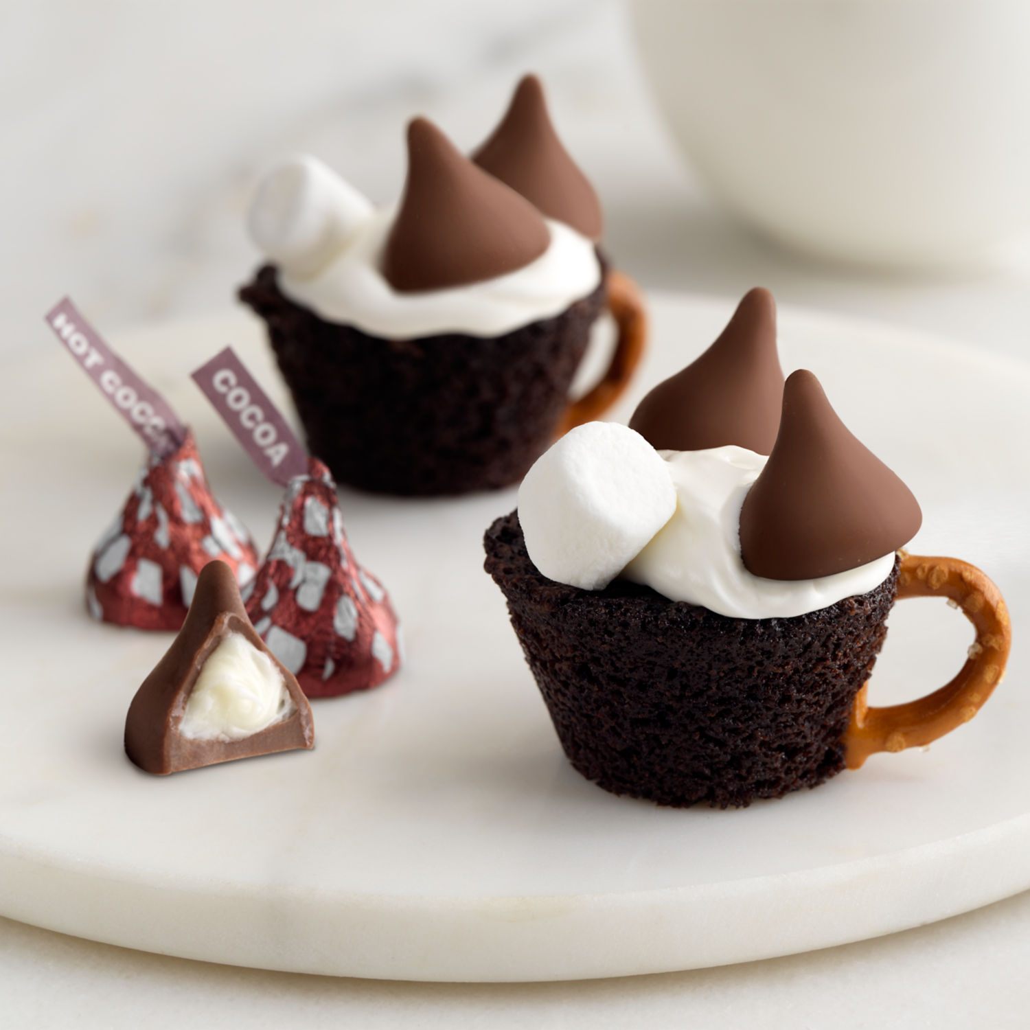 Promotional graphic featuring HERSHEY'S KISSES Hot Cocoa Flavored in a Christmas mug