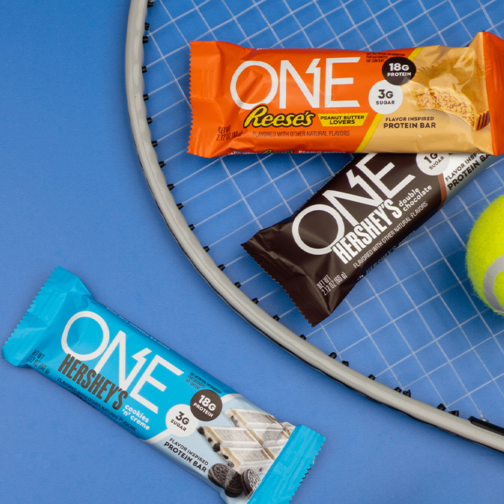 Promotional graphic featuring assorted ONE Bars arranged near sports equipment